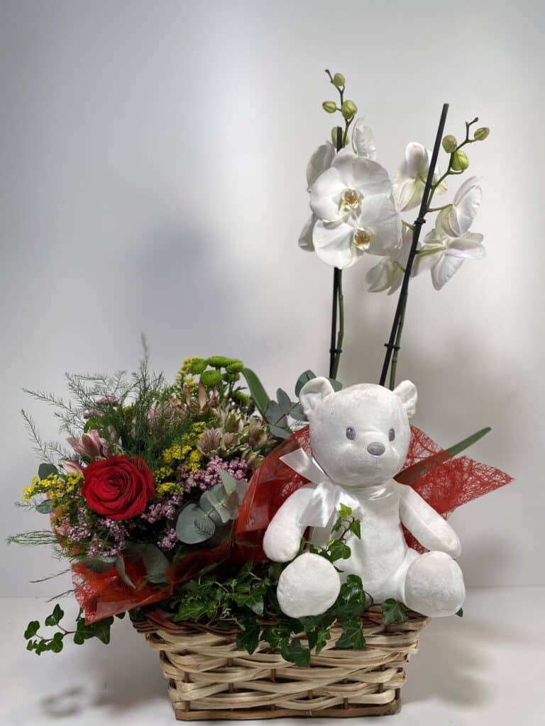 composición para San Valentín de orquídeas, bouquet silvestre y peluche en una cesta de mimbre