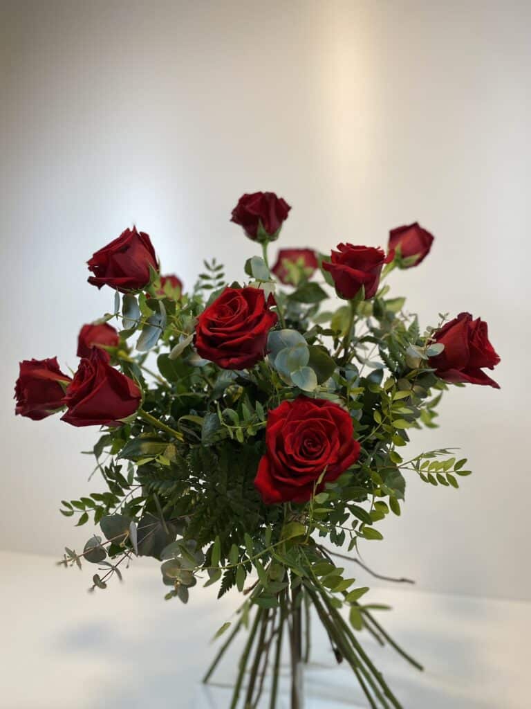 Ramo de rosas rojas con ramaje verde variado