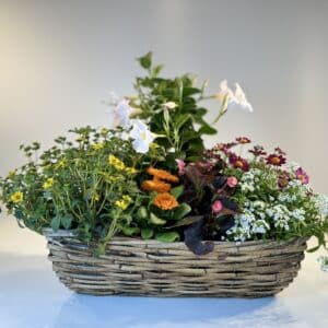 composición de flores primaverales en cesta de mimbre rectangular
