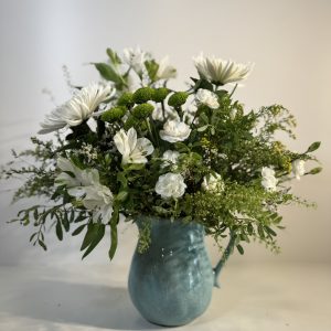 Jarra con flores variadas en tonos blancos