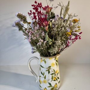 Jarra de limones con flores secas en tonos rosas