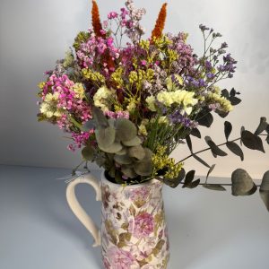Jarra con flores en tonos rosa
