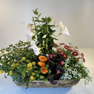 composición de flores primaverales en cesta de mimbre rectangular