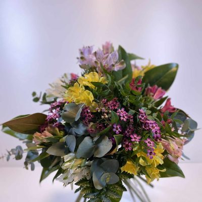 Ramo de alstroemeria en colores variados, acompañada de verdes y flores variadas.