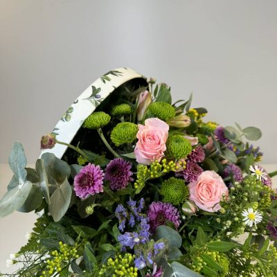 Baúl con flores coloridas de temporada en tonos rosas, morados, verdes y amarillos.