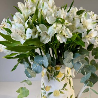 Jarra decorada con limones y bouquet de alstroemeria blanca