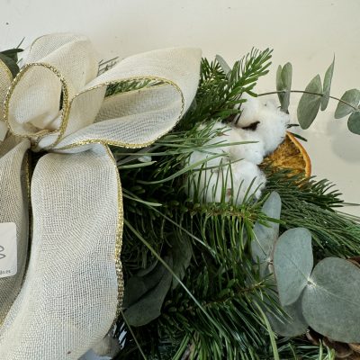 Corona natural con piñas, limón, canela, algodón y lazo blanco
