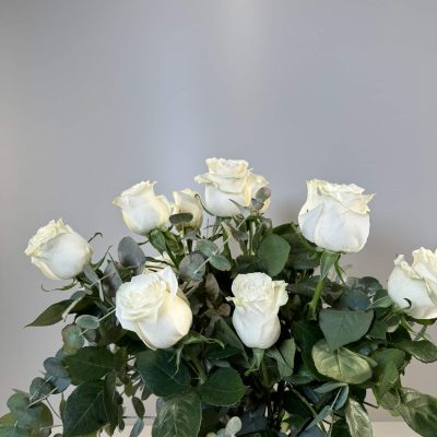 Jarrón de cristal con 12 rosas blancas